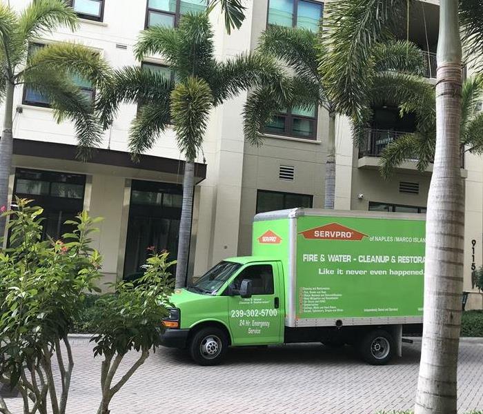 A SERVPRO vehicle parked in front of a building. 